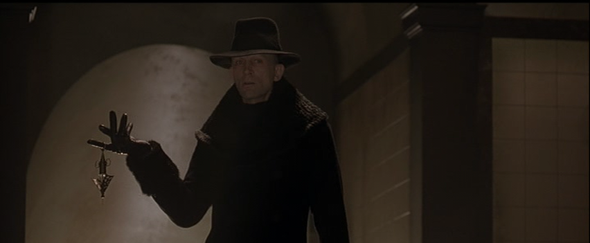 Richard O'Brien as Mr. Hand Holding a Syringe